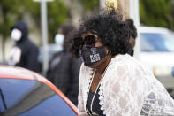 A woman watches as people gather for a peaceful demonstration, Thursday, April 22, 2021, in Elizabeth City, N.C., protesting the shooting of Andrew Brown Jr., 42, by a deputy sheriff trying to serve a search warrant. (AP Photo/Gerry Broome)