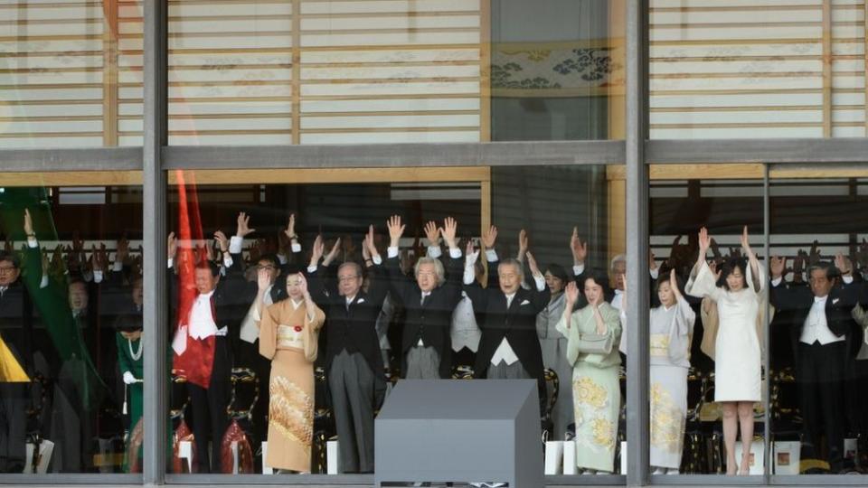 Dignatarios y representantes del gobierno japonés le dan un saludo "banzai" (diez mil años) a su nuevo emperador durante la ceremonia en el Palacio Imperial de Tokio.