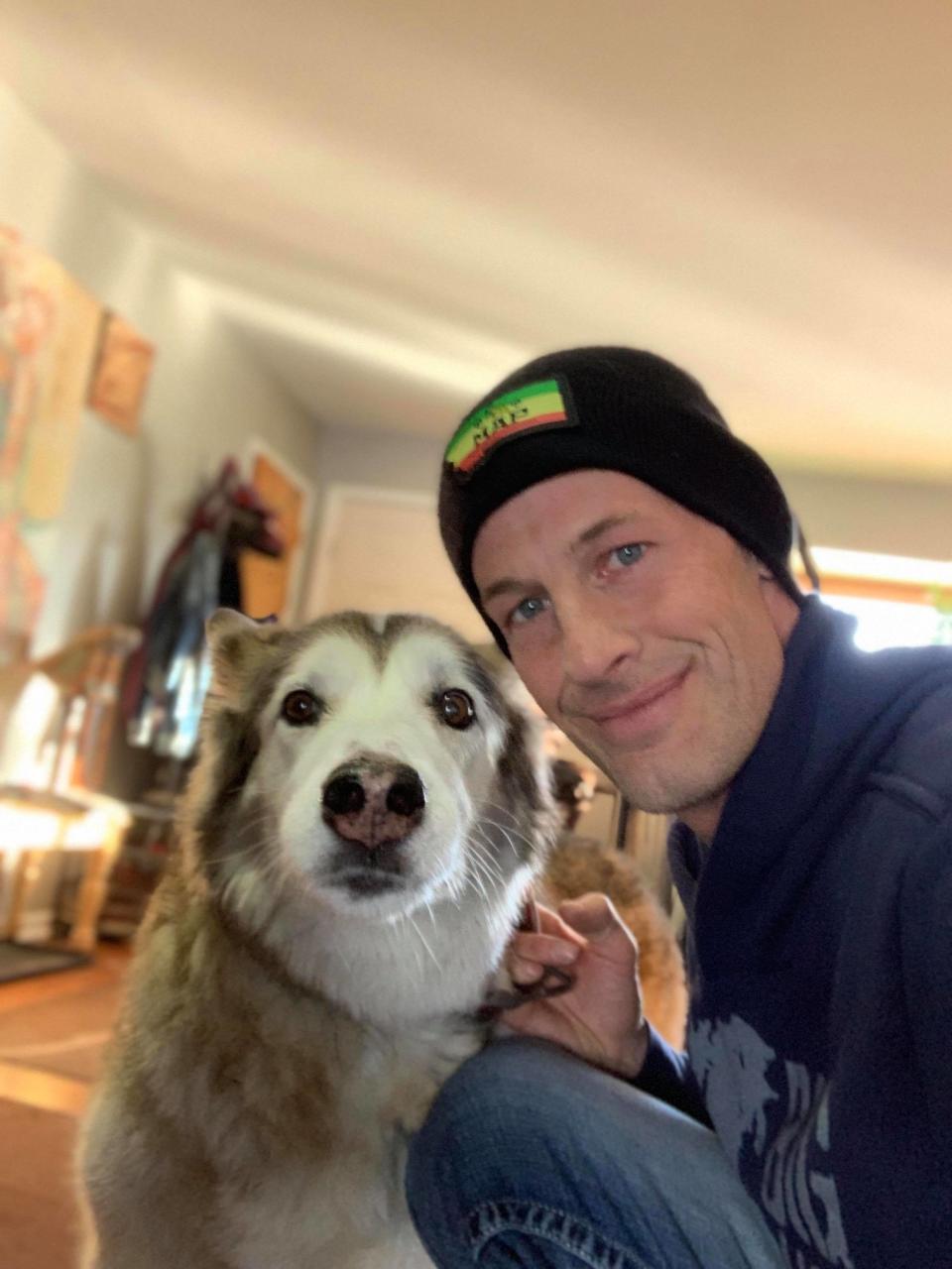 Ryan Arens poses with his malamute white shepherd mix named Hara.