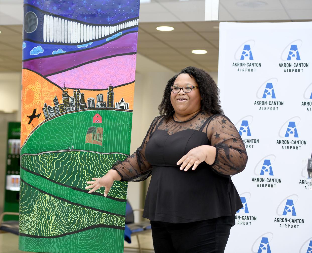 Artist Jessica Travis of Akron talks about the inspiration behind her piece during the unveiling of Wing Art at the Akron-Canton Airport.
