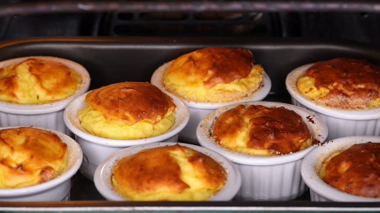 souffle baking in individual ramekins in an oven 