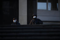 Two men wearing face masks to help curb the spread of the coronavirus walk into the underpass under the street during sunset in Moscow, Russia, Wednesday, Dec. 2, 2020. Russia has registered a record number of coronavirus deaths for a second straight day. Currently, there is a country-wide mask mandate and mostly mild restrictions that vary from region to region. (AP Photo/Alexander Zemlianichenko)