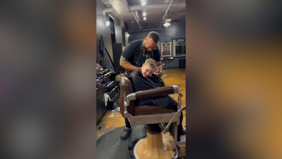 Barber plays adorable game during child's haircut