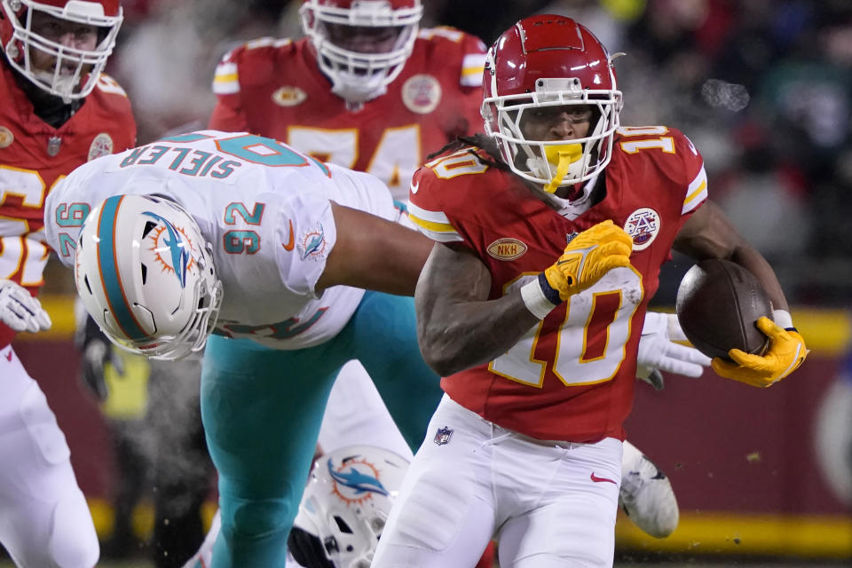 Kansas City Chiefs running back Isiah Pacheco (10) runs in front of Miami Dolphins defensive tackle Zach Sieler (92) during the first half of an NFL wild-card playoff football game Saturday, Jan. 13, 2024, in Kansas City, Mo. (AP Photo/Ed Zurga)