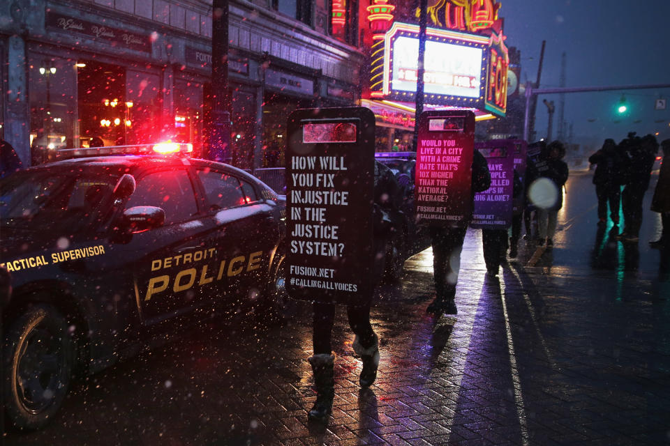 DETROIT, MI - MARCH 03: Demonstrators march with signs made to look like law enforcement riot shields while protesting against police violence outside the historic Fox Theatre before the GOP presidential debate March 3, 2016 in Detroit, Michigan. Voters in Michigan will go to the polls March 8 for the stateÕs primary. (Photo by Chip Somodevilla/Getty Images)