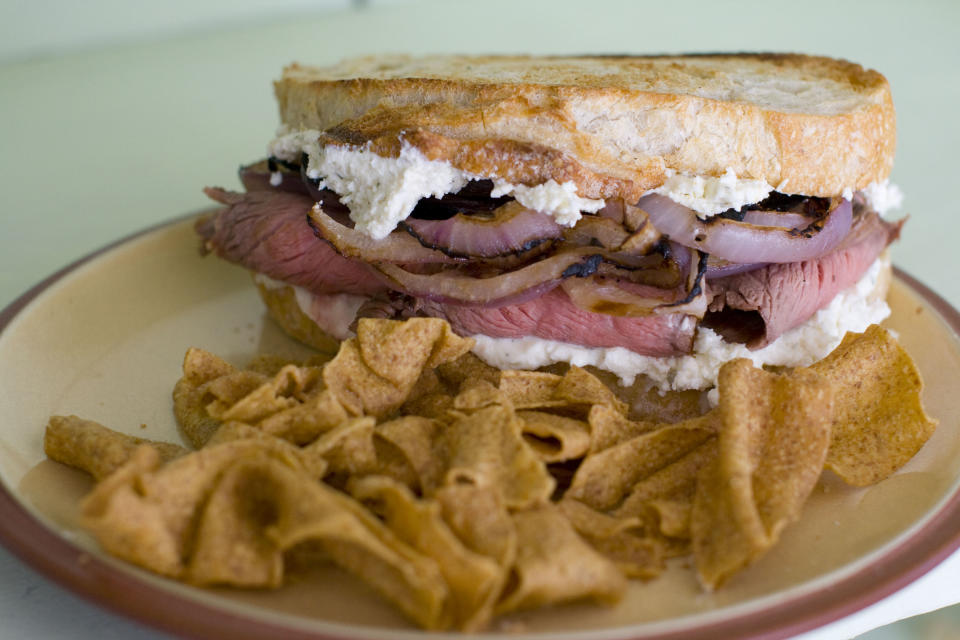 In this Feb. 6, 2012 image taken in Concord, N.H., a sandwich made of flank steak with slices of red onion marinated in Guinness lager and Boursin cheese, is shown. (AP Photo/Matthew Mead)