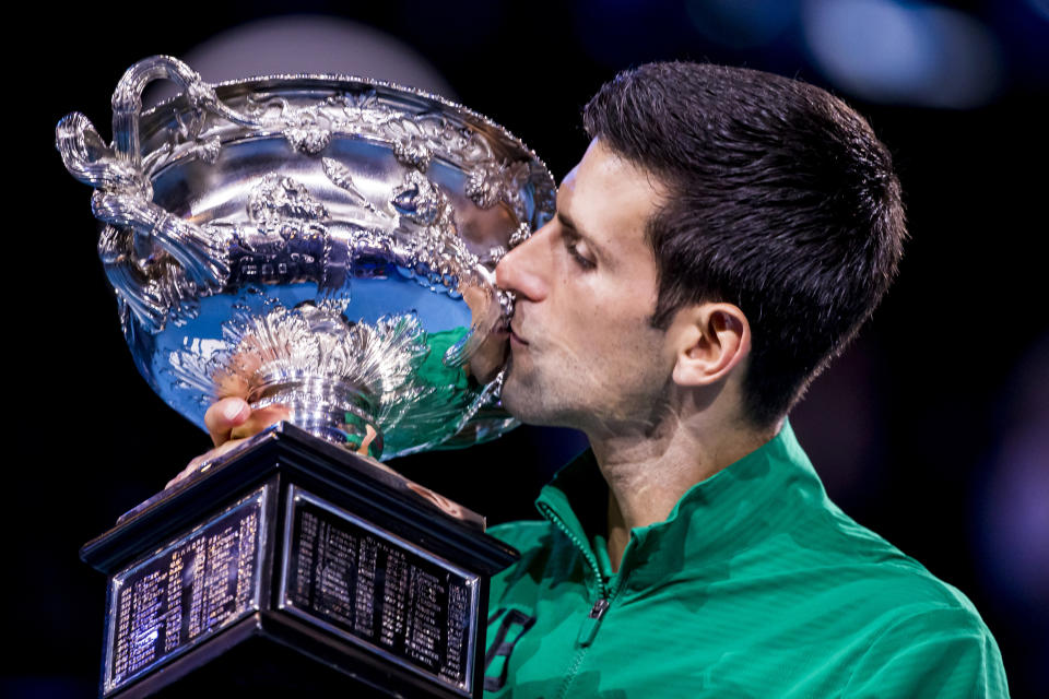 Novak Djokovic kisses his trophy after winning the finals of the 2020 Australian Open.