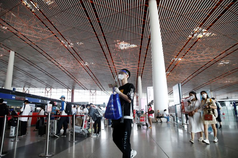 Man wearing protective gear is seen at the departure hall of Beijing Capital International Airport