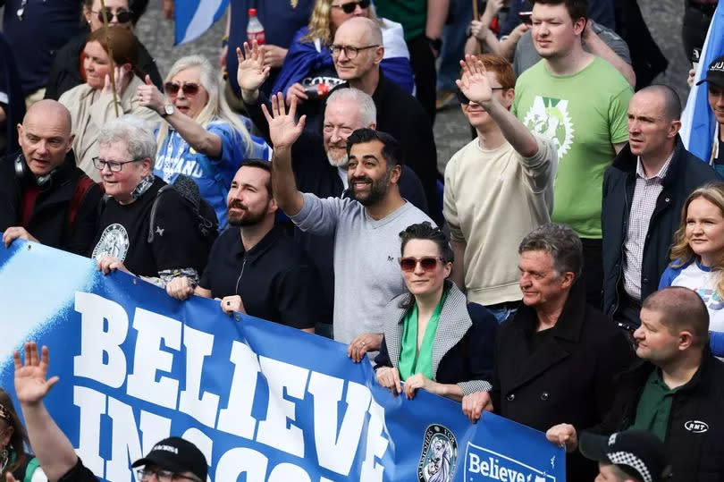 Scotland First Minister Humza Yousaf (C) and actor Martin Compston (CL) join members of the public as they attend a march and rally in support for an independent Scotland on April 20, 2024 in Glasgow, Scotland.