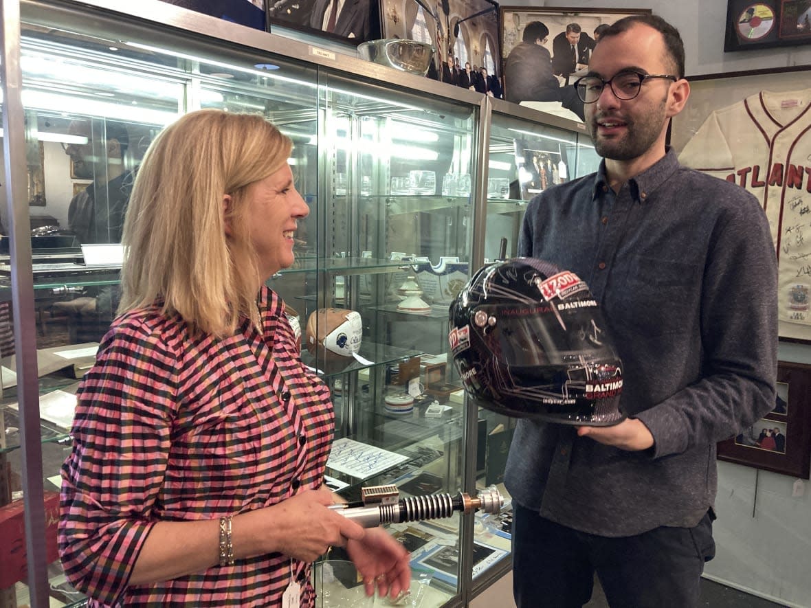 Elizabeth Haynie Wainstein, left, and Zachary Diaz, of The Potomack Company, display items from the estate of Gen. Colin Powell, Thursday, Nov. 3, 2022, in Alexandria, Va. (AP Photo/Matthew Barakat)