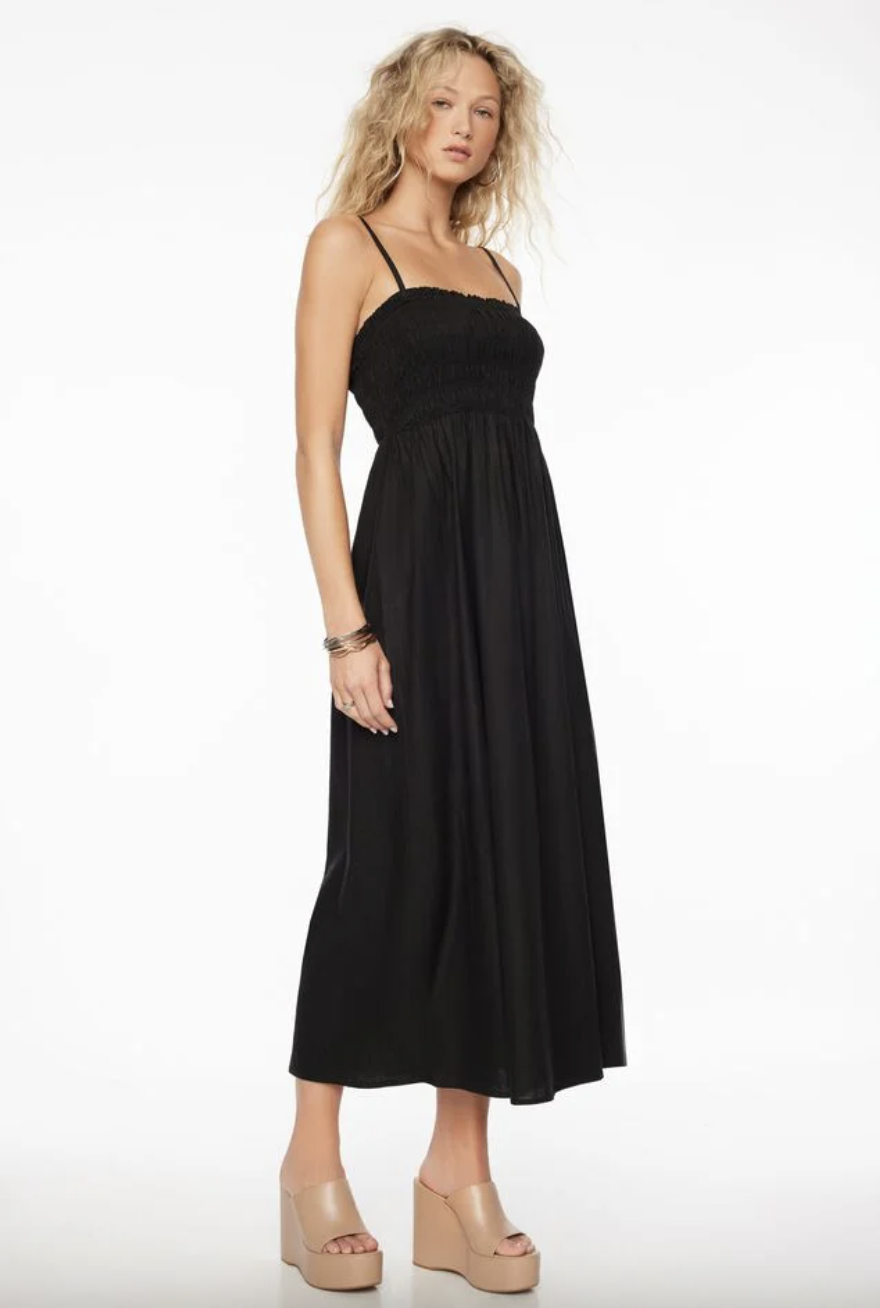 blonde model with curly hair wearing black Neve Linen Maxi Dress (photo via Dynamite)