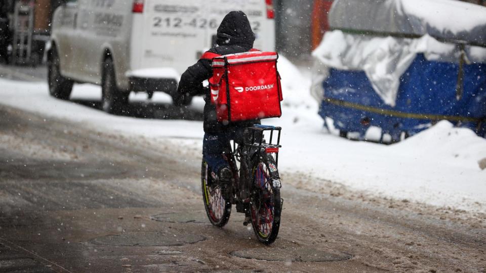 PHOTO: In this Feb. 18, 2021, file photo, a food delivery worker is seen as snowfall blankets the area in New York. (Anadolu Agency via Getty Images, FILE)