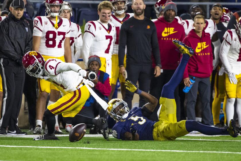 Notre Dame cornerback Cam Hart forces USC receiver Mario Williams (4) to fumble the ball