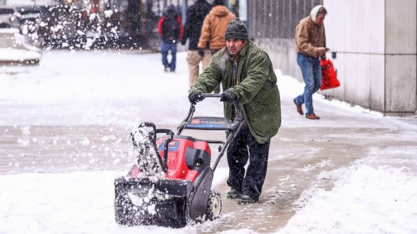 PHOTO: A man cleans a sidewalk with a snowplow during snowfall in Chicago, Dec. 24, 2017.  (Bilgin S. Sasmaz/Anadolu Agency/Getty Images)