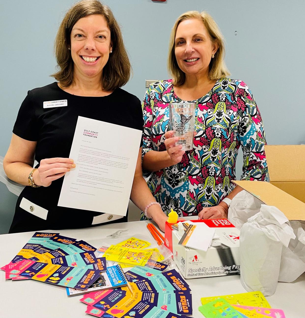 Jennifer Johnston, left, and Michelle Stout, of Gulf Coast Community Foundation, make a thank-you package for students at Cork Elementary School for their philanthropy.