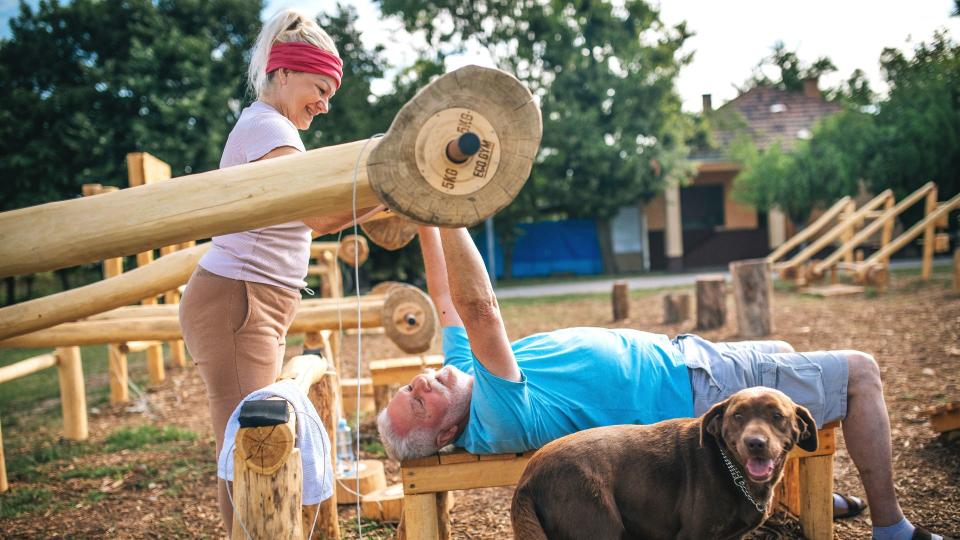 Man and woman exercising outside with dog