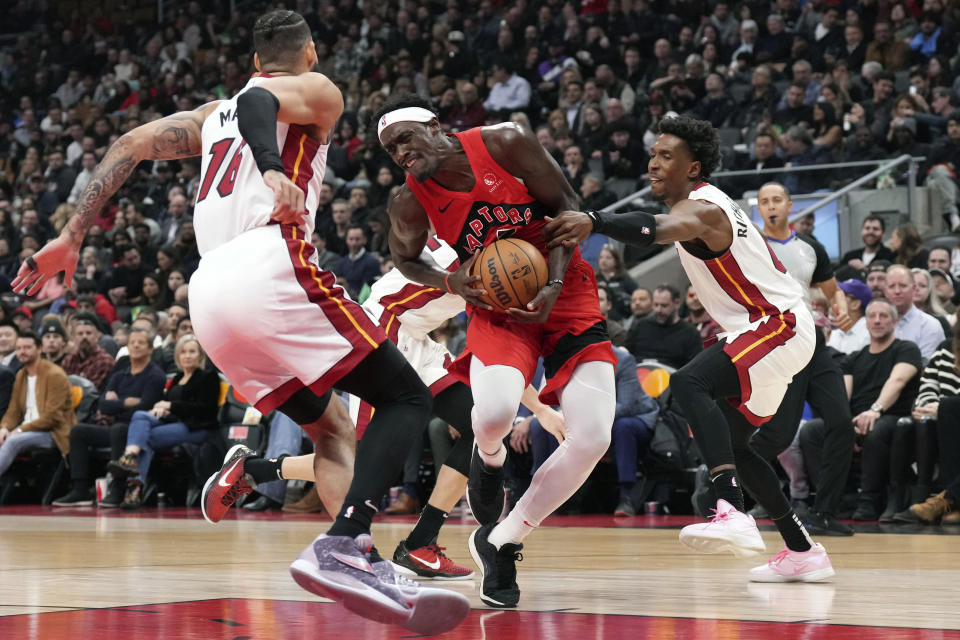 Toronto Raptors' Pascal Siakam drives between Miami Heat's Caleb Martin, left, and Josh Richardson during the first half of an NBA basketball game, Wednesday, Dec. 6, 2023 in Toronto. (Chris Young/The Canadian Press via AP)