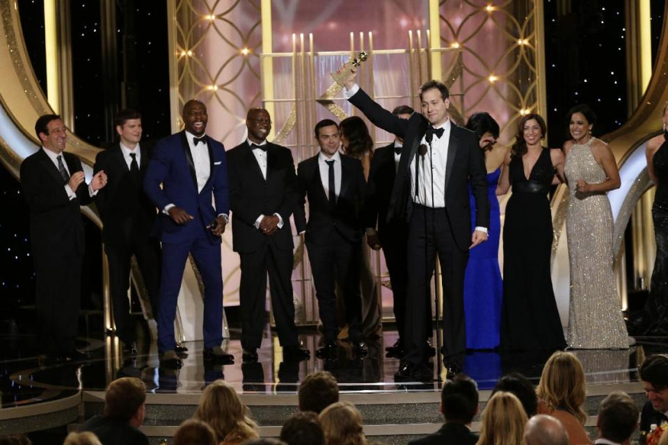 En esta imagen difundida por NBC, Dan Goor acepta el Globo de Oro a la mejor serie de comedia por "Brooklyn Nine-Nine" , junto a miembros del equipo de producción y del elenco, el domingo 12 de enero del 2014 en Beverly Hills, California. (AP Foto/NBC, Paul Drinkwater)