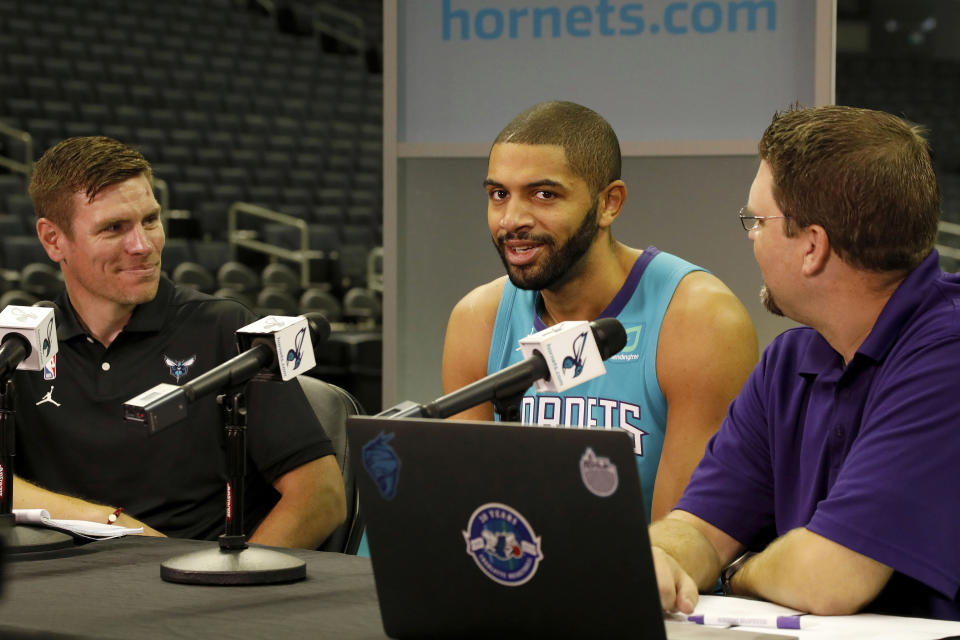 Charlotte Hornets' Nicolas Batum, of France, center, talks with radio personalities during the NBA basketball team's media day in Charlotte, N.C., Monday, Sept. 30, 2019. (AP Photo/Bob Leverone)