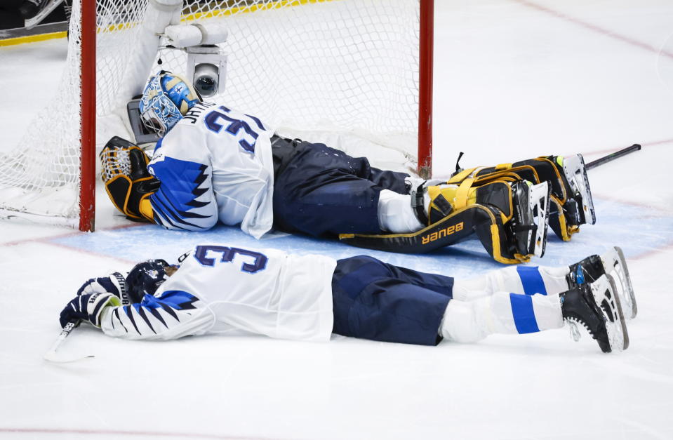 Finland goalie Juha Jatkola, top, and defenseman Ruben Rafkin react after losing to Canada after the gold medal game at the world junior hockey championship, Saturday, Aug. 20, 2022 in Edmonton, Alberta. (Jeff McIntosh/The Canadian Press via AP)