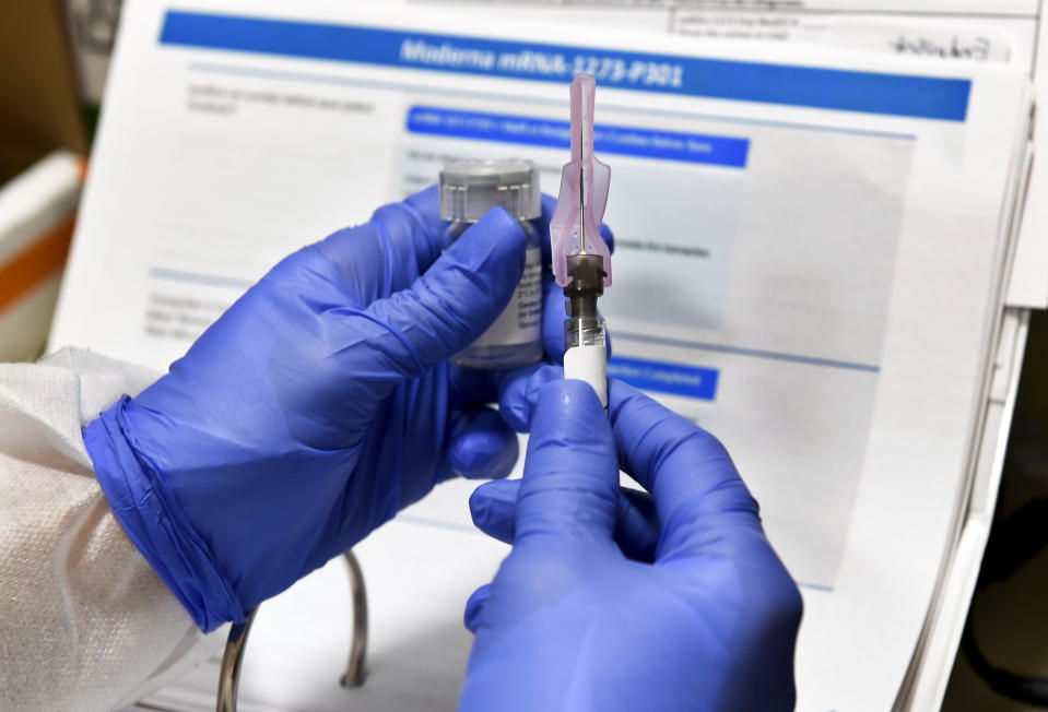 Nurse Kathe Olmstead prepares a shot as the world's biggest study of a possible COVID-19 vaccine, developed by the National Institutes of Health and Moderna Inc., gets underway Monday, July 27, 2020, in Binghamton, N.Y. (AP Photo/Hans Pennink)