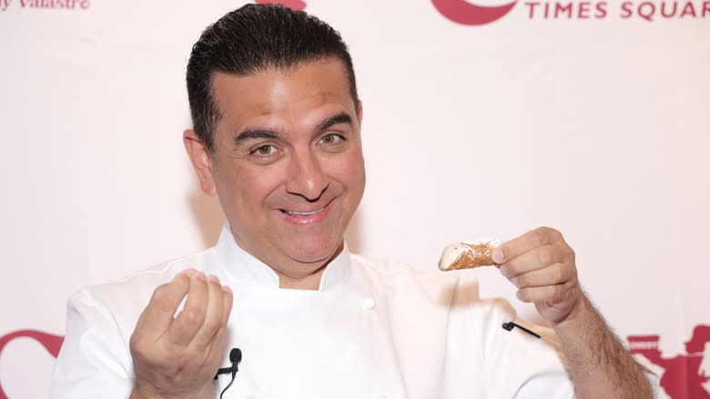 Buddy Valastro holds up a pastry  