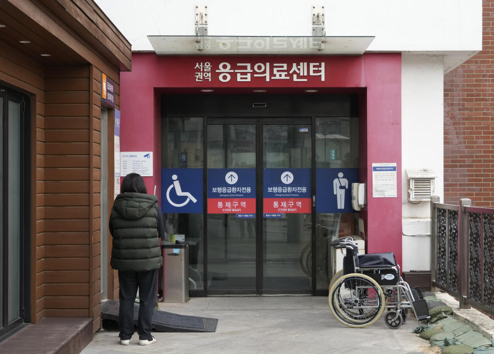 A woman stands in front of an emergency center at Seoul National University Hospital in Seoul, South Korea, Thursday, Feb. 29, 2024. South Korea’s government made a last appeal to junior doctors to end a walkout, with hours left to go before the Thursday deadline on its threats to suspend medical licenses and prosecute the strikers. (AP Photo/Ahn Young-joon)
