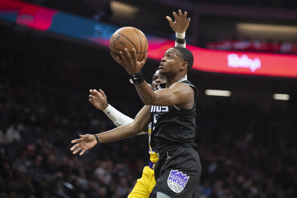 Sacramento Kings guard De'Aaron Fox (5) scores past Los Angeles Lakers guard Dennis Schroder during the first half of an NBA basketball game in Sacramento, Calif., Wednesday, Dec. 21, 2022. (AP Photo/José Luis Villegas)