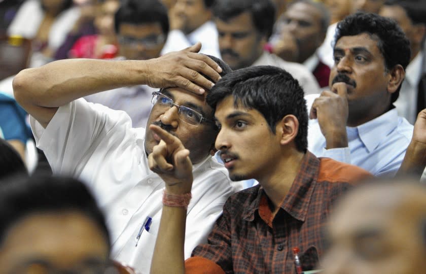 A college applicant and his father in Bangalore, India, watch a screen displaying seats allotted to students after the son passed an entrance test in 2011.