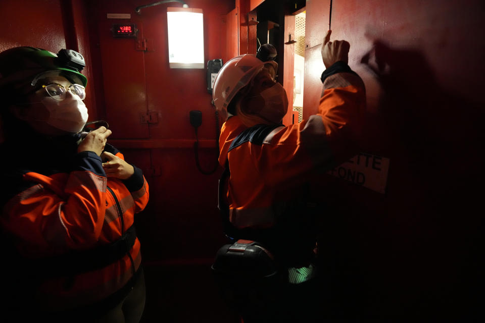 Emilie Grandidier, spokesperson for French radioactive waste management agency Andra, left, and Audrey Guillemenet, geologist and spokesperson, stand in the elevator in Bure, eastern France, Thursday, Oct. 28, 2021. Nuclear power is a central sticking point as negotiators plot out the world’s future energy strategy at the climate talks in Glasgow, Scotland. (AP Photo/Francois Mori)