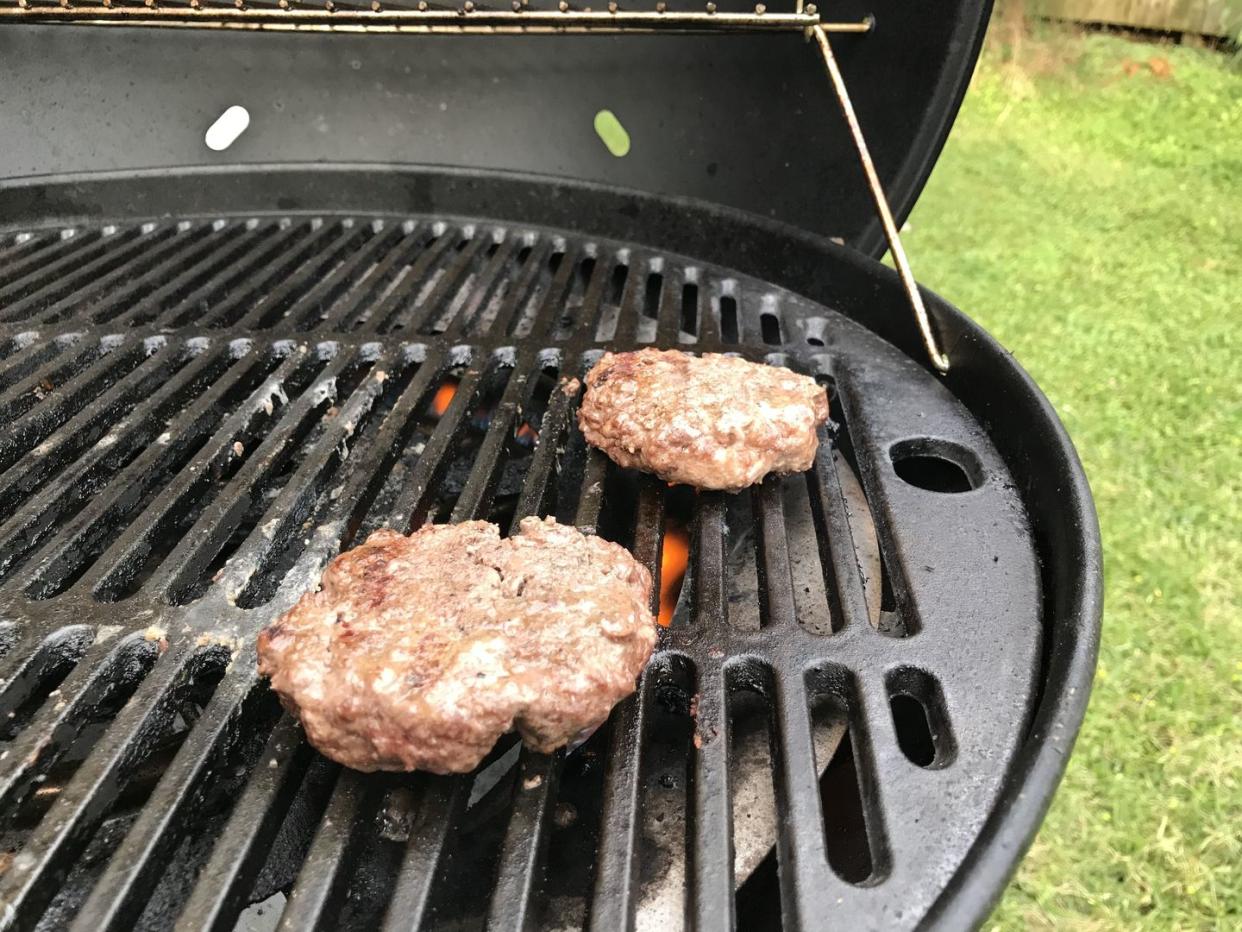 two burgers on a grill outside