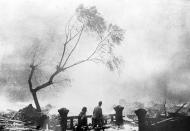 FILE - In this Aug. 9, 1945, file photo, survivors of the atomic bomb attack of Nagasaki, Japan, walk through the destruction as fire rages in the background. The city of Nagasaki in southern Japan marks the 75th anniversary of the U.S. atomic bombing of Aug. 9, 1945. It was a second nuclear bomb dropped by the U.S. three days after it made the world’s first atomic attack on Hiroshima. Japan surrendered on Aug. 15, ending World War II and its nearly a half-century aggression toward Asian neighbors. Dwindling survivors, whose average age exceeds 83, increasingly worry about passing their lessons on to younger generations. (AP Photo, File)