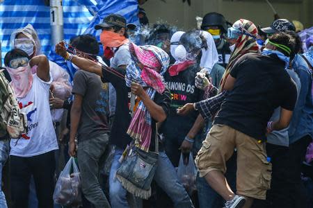 An anti-government protester uses a slingshot during clashes with the police at the metropolitan police headquarters in Bangkok December 2, 2013. REUTERS/Athit Perawongmetha