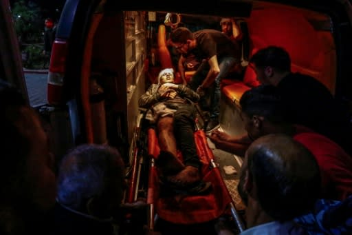 Paramedics carry the body of a wounded Palestinian at a hospital in Beit Lahia, northern Gaza Strip