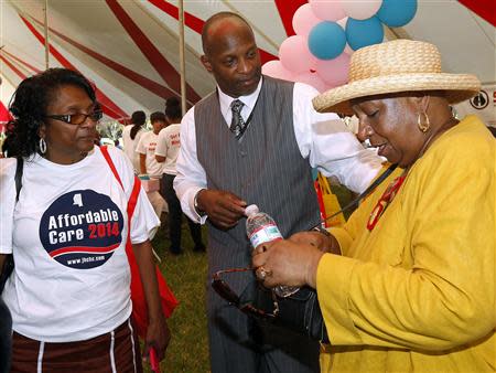 Reverend Michael Minor (C) talks to Ann Littleton (R) and Alice Lewis at a rally held by supporters of the Affordable Care Act (ACA), widely referred to as "Obamacare", outside the Jackson-Hinds Comprehensive Health Center in Jackson, Mississippi October 4, 2013. REUTERS/Jonathan Bachman