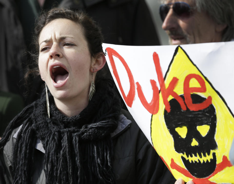 Kate Fulbright, of Charlotte, N.C., shouts about Duke Energy's coal plants during a protest near Duke Energy's headquarters in Charlotte, N.C., Thursday, Feb. 6, 2014. Duke Energy estimates that up to 82,000 tons of ash has been released from a break in a 48-inch storm water pipe at the Dan River Power Plant on Sunday. (AP Photo/Chuck Burton)