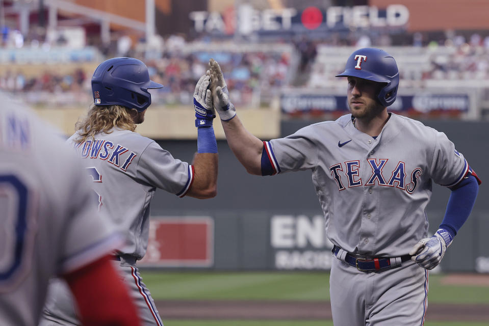 Texas Rangers' Mitch Garver, right, high-fives Travis Jankowski after Garver hit a home run against the Minnesota Twins during the second inning of a baseball game Friday, Aug. 25, 2023, in Minneapolis. (AP Photo/Stacy Bengs)