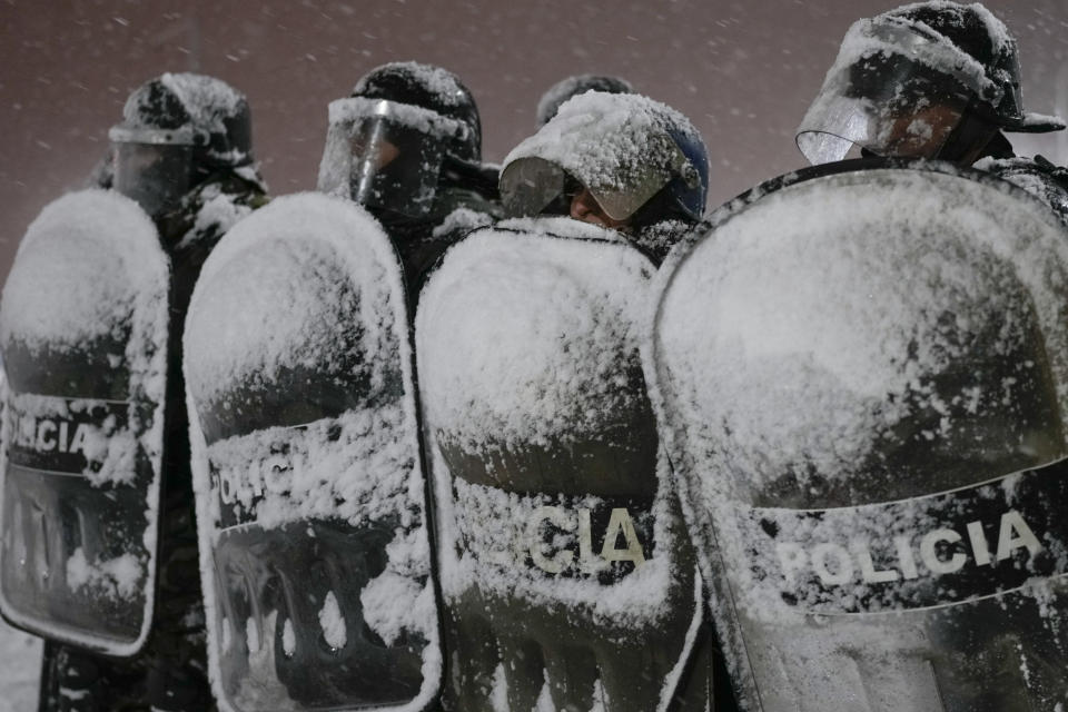 Police guard stand in a snowstorm guarding a supermarket, after reports that people tried to break into the store, in Bariloche, Argentina, Aug. 23, 2023. (AP Photo/Natacha Pisarenko)