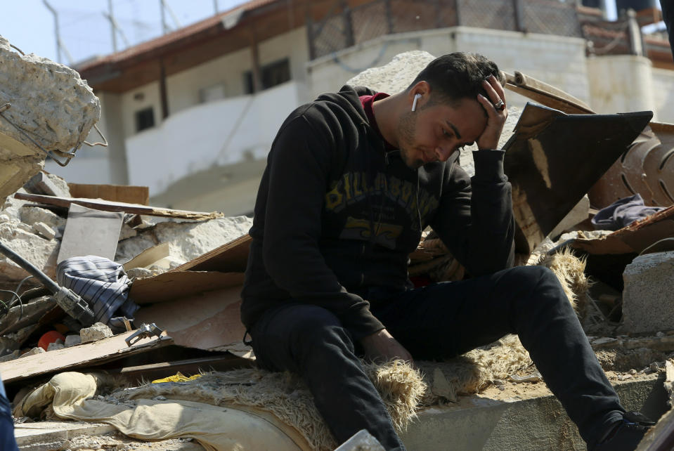 In this Wednesday, March 27, 2019 photo, Palestinian groom Walid al-Shawa sits in the rubble of a building that was destroyed in an Israeli airstrike late Monday, in Gaza City. Al-Shawa was due to get married in two weeks, but an Israeli airstrike on a Gaza City building destroyed his sister's apartment, where he had rented a second floor bedroom and had amassed everything he and his bride needed for the wedding. (AP Photo/Adel Hana)