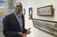 FILE - In this Jan. 11, 2018 photo, Alan Page, NFL Hall of Famer and retired Minnesota Supreme Court justice, stands in Minneapolis, by a photo of black babies labeled "Alligator Bait." Page has counted art collection among his many life pursuits, and the former Vikings star has two of his prized pieces up for sale through a New York auction house, each valued at more than $200,000. (AP Photo/Steve Karnowski, File)