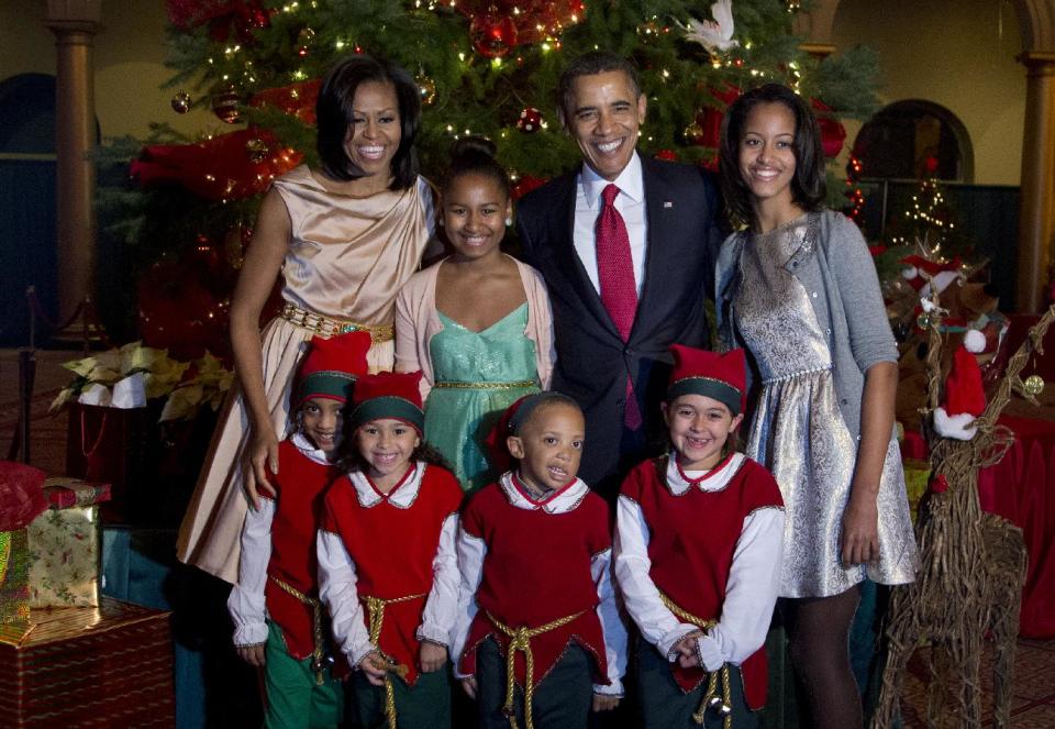 The first family, from left, first lady Michelle Obama, Sasha Obama, President Barack Obama and Malia Obama, pose with children dressed like elves at the National Building Museum in Washington, Sunday, Dec. 9, 2012. The first family is attending the taping of the 2012 Christmas in Washington. (AP Photo/Manuel Balce Ceneta)