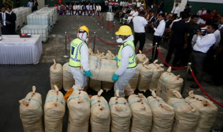 Police officers carry a haul of seized cocaine sack to be destroyed under judicial supervision in Katunayake, Sri Lanka January 15, 2018. REUTERS/Dinuka Liyanawatte