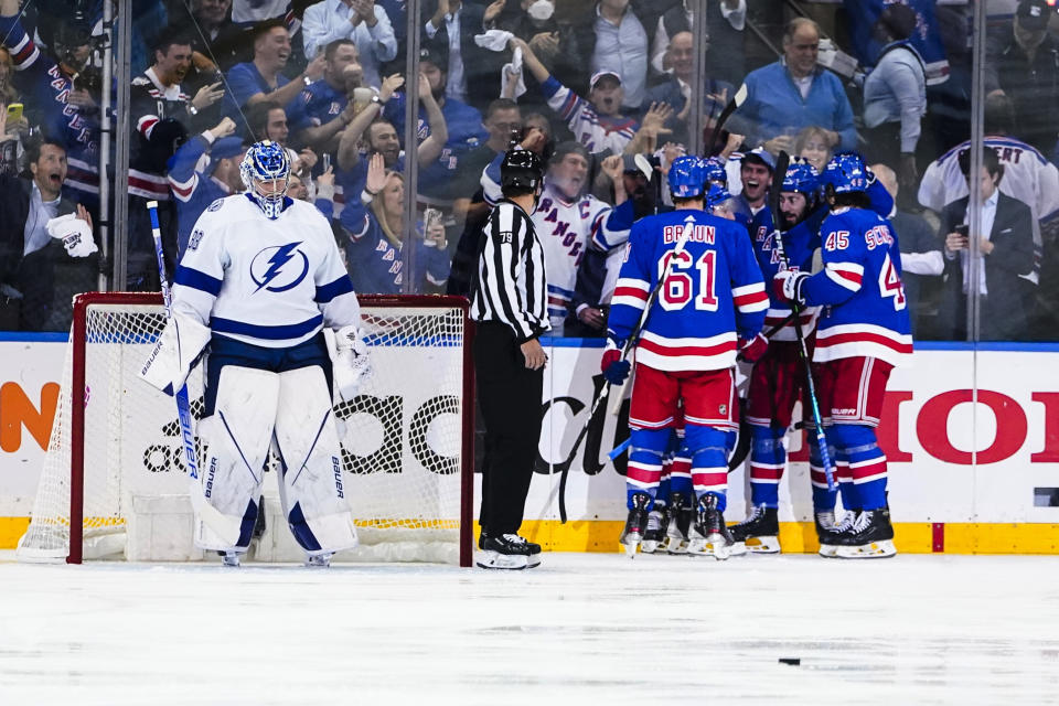 Tampa Bay Lightning goaltender Andrei Vasilevskiy, left, looks down as the New York Rangers celebrate a goal by Chris Kreider during the first period in Game 1 of the NHL hockey Stanley Cup playoffs Eastern Conference finals Wednesday, June 1, 2022, in New York. (AP Photo/Frank Franklin II)