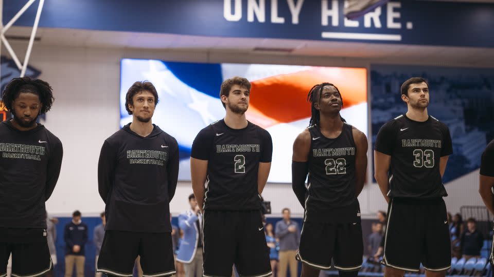 Romeo Myrthil, second from left, and Cade Haskins, third from left, stand with fellow Dartmouth teammates during the game against Columbia University. - Laura Oliverio/CNN