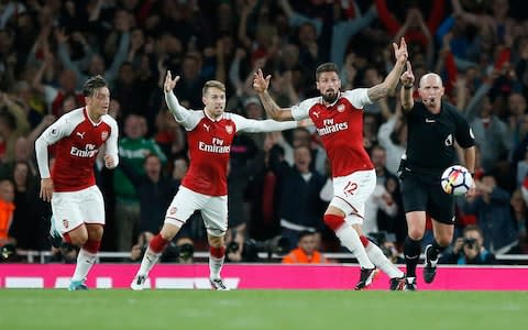 Giroud and his Arsenal team-mates celebrate after ref Mike Dean rules his header crossed the line - Credit: AP