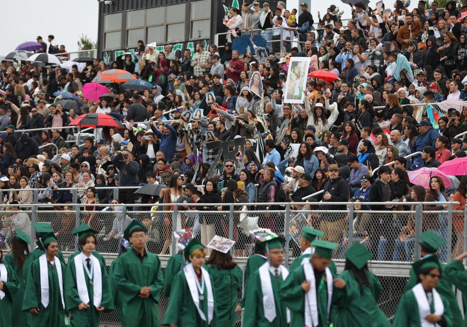 Umbrellas pop up in the bleachers Tuesday as Pacifica High School's commencement is underway in Oxnard. The National Weather Service office in Oxnard recorded about five-hundredths of an inch of rain, which is unusual for June.