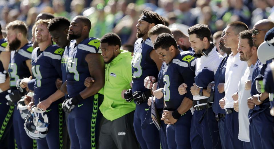 <p>Seattle Seahawks players, including quarterback Russell Wilson (3) lock arms during the national anthem before an NFL football game against the San Francisco 49ers, Sunday, Sept. 25, 2016, in Seattle. (AP Photo/John Froschauer) </p>