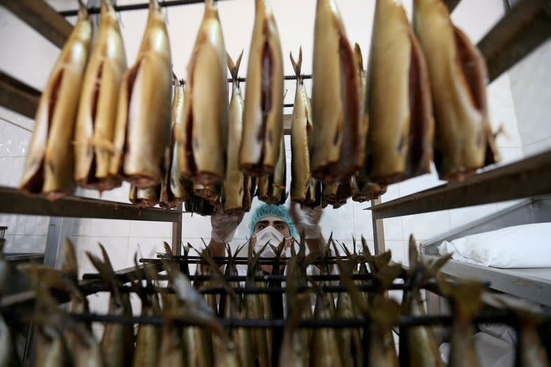 A worker prepares Ringa, salted smoked fish traditionally eaten by Palestinians during the holiday of Eid al-Fitr marking the end of Ramadan, amid concerns about the spread of the coronavirus disease