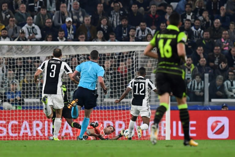 Juventus' Alex Sandro (C) scores auto-goal against teammate Gianluigi Buffon during their match against Sporting CP at the Juventus stadium on October 17, 2017 in Turin