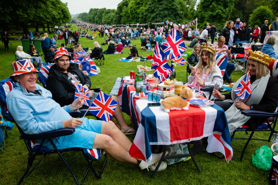 Revellers carrying Union Jacks take part in a Platinum Jubilee Big Lunch On The Long Walk in Windsor Great Park to mark Queen Elizabeth II's Platinum Jubilee on 5th June 2022 in Windsor, United Kingdom. The Big Lunch initiative to encourage communities to celebrate their connections began in 2009 and this was the first time that the event had taken place on the Long Walk. (photo by Mark Kerrison/In Pictures via Getty Images)